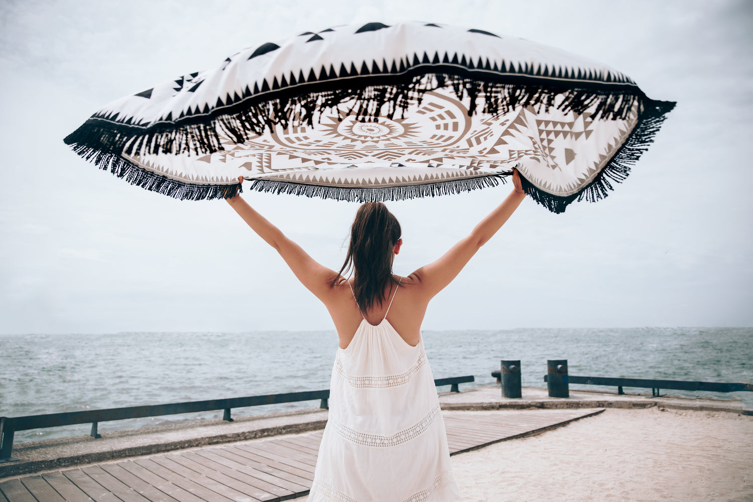 Women and sea with beach towel in the wind